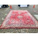 A LARGE RED PATTERNED CARPET - VERY POOR CONDITION 130 INCH X 184 INCH