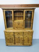 A HONEY PINE 3 DRAWER 3 DOOR DRESSER BASE WITH 2 DOOR GLAZED TOP WITH CENTRAL CUPBOARD AND SHELF