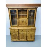 A HONEY PINE 3 DRAWER 3 DOOR DRESSER BASE WITH 2 DOOR GLAZED TOP WITH CENTRAL CUPBOARD AND SHELF