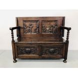 A REPRODUCTION OAK MONKS SETTLE, THE LOWER BASE PANELS CARVED WITH GREEN MAN MOTIF,