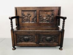 A REPRODUCTION OAK MONKS SETTLE, THE LOWER BASE PANELS CARVED WITH GREEN MAN MOTIF,