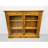 A MODERN HONEY PINE TWO DOOR BOOKCASE (GLASS MISSING FROM ONE DOOR) WIDTH 126CM, HEIGHT 107CM,