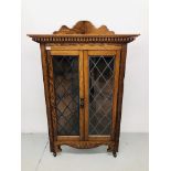 AN OAK CORNER DISPLAY CABINET WITH LEADED GLASS DOORS,