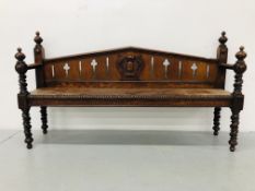 AN ANTIQUE OAK HALL BENCH WITH RIVEN DESIGN TO SUPPORTS AND SHIELD MOTIF TO BACK RESTS
