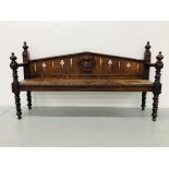 AN ANTIQUE OAK HALL BENCH WITH RIVEN DESIGN TO SUPPORTS AND SHIELD MOTIF TO BACK RESTS