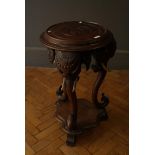A Colonial hardwood jardiniere stand with elephant head monopodia, each with curling tusks