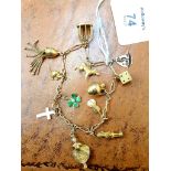 A gold charm bracelet, the fancy fetter and three link chain, suspending twelve charms including a