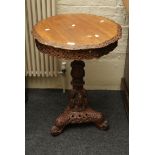 A late 19th/ early 20th century Anglo Indian carved hard wood tripod table with pierced detail to