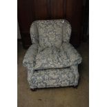 A well upholstered, deep seated wing chair, with blue and floral fabric