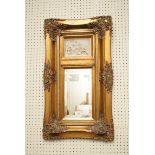 A gilt framed Trumean type wall mirror, with composition relief panel