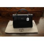 A Hermes type black Kelly handbag, with silver coloured metalwork, lock and key