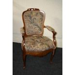 An 18th century French walnut fauteuil, with open arms, raised on slender cabriole supports