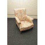 A Victorian scroll back Country house type armchair with stuffed over upholstery, on turned