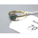 An emerald and diamond cluster ring, the circular emerald, millegrain mounted within a scalloped
