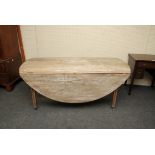 A George III Country made oval wake table, with planked scrub top, raised on square castored