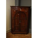 A George III mahogany two door corner cupboard with shaped doors, 97cm wide, together with a