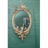 A 19th century carved wood and gilt gesso oval girandole wall mirror with three candle scones,