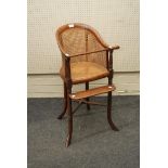 A Regency mahogany child's high chair, with split cane back and seat, raised on splay supports