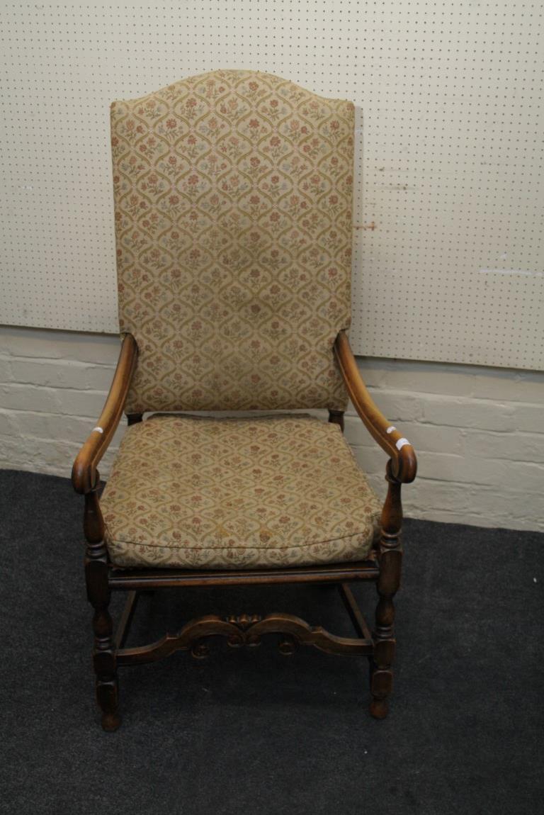 A Carolean style cane seated open armchair, with scroll arms
