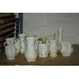 A collection of Belleek porcelain wares decorated with shamrocks including jugs, vase and other