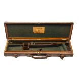 JOHN RIGBY & CO. A BRASS-CORNERED OAK AND LEATHER SINGLE GUNCASE, fitted for 30in. barrels, the