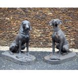 A SET OF TWO CAST IRON HUNTING DOGS, in a sitting position set on an oval base, one with woodcock