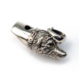 A STERLING SILVER DOG WHISTLE, marked 'STERLING', with glass eyes and lanyard ring, measuring