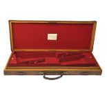 A BRASS-CORNERED OAK AND LEATHER DOUBLE GUNCASE, fitted for 30in. barrels, the interior lined with