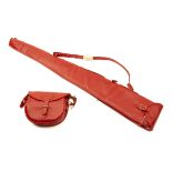 AN UNUSED RED LEATHER SINGLE GUNSLIP WITH MATCHING CARTRIDGE BAG, with shoulder straps and brass