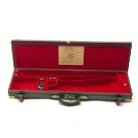 JOHN RIGBY & CO. A BRASS-CORNERED LEATHER SINGLE GUNCASE, fitted for 30in. barrels, the interior