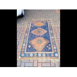 An antique Middle Eastern carpet with navy blue gr