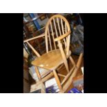 A child's antique Ercol stick back rocking chair