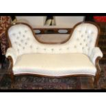 A Victorian settee with shaped back on cabriole su