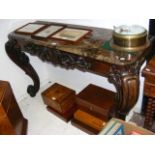 A decoratively carved console table with cabriole