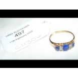 A blue stone and diamond ring in gold setting