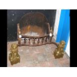 A decorative antique fire grate with ornate brass