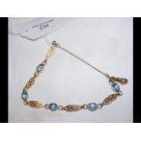 A lady's 9ct gold and blue stone bracelet