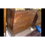 A Georgian country oak chest of two short and thre