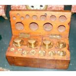 A set of antique bronze apothecary weights in fitt