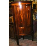 An antique bow fronted corner cupboard on stand