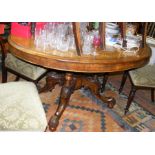 A Victorian inlaid walnut oval dining table on sha