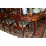 A Chinese hardwood extending dining table with two