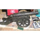 A heavy cast antique cannon on wheels - 148cm long