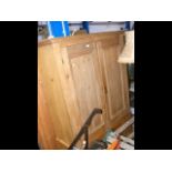 An antique pine wardrobe with drawer below