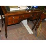 An antique desk with green leather top and drawers