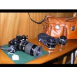 An Olympus OM-1 SLR camera with lenses and bag