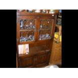 An 'Old Charm' oak display cabinet with lead glazed top section