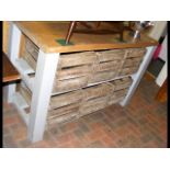 A shabby chic kitchen island with six crates below