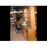 A pine dresser with cupboards above