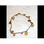 A gold charm necklace with coins, etc.